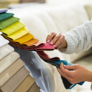 the-woman-chooses-the-fabric-on-the-sofa-textile-industry-background-tissue-catalog.jpg